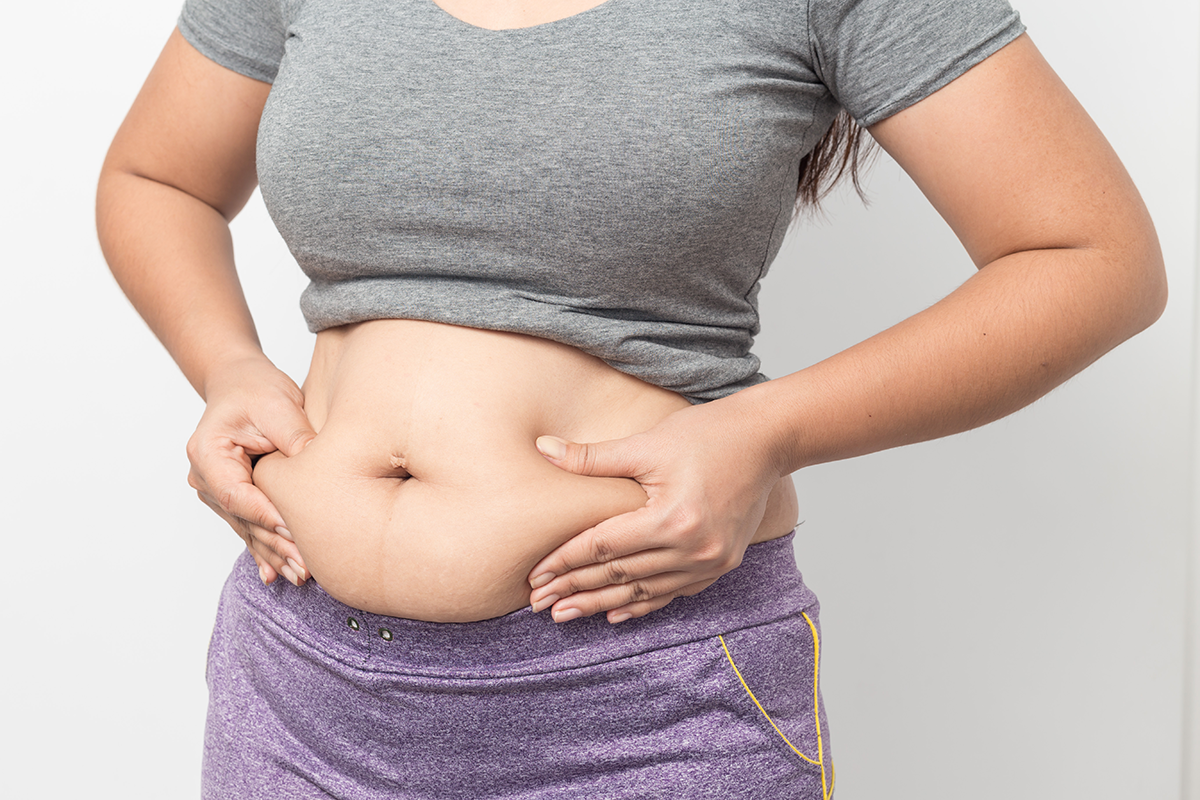 overweight woman hand pinching excessive belly fat overweight woman hand pinching excessive belly fat