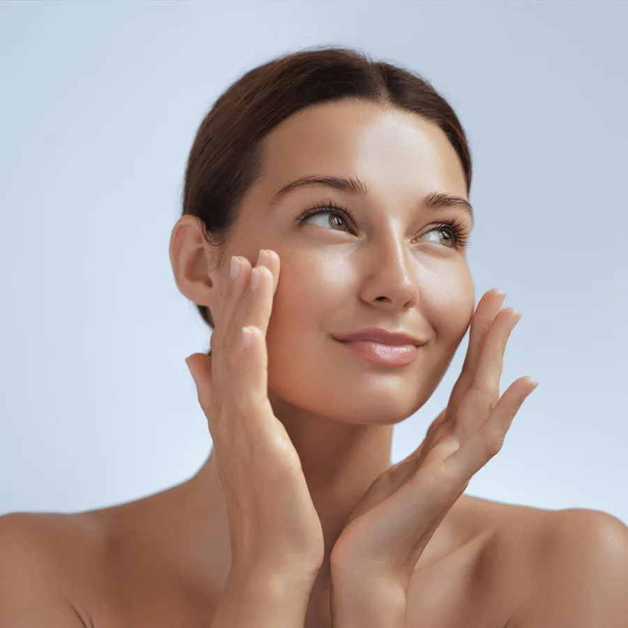 Skincare. Woman with beautiful face touching healthy facial skin. Beautiful portrait of smiling Asian girl model with natural makeup enjoys...
